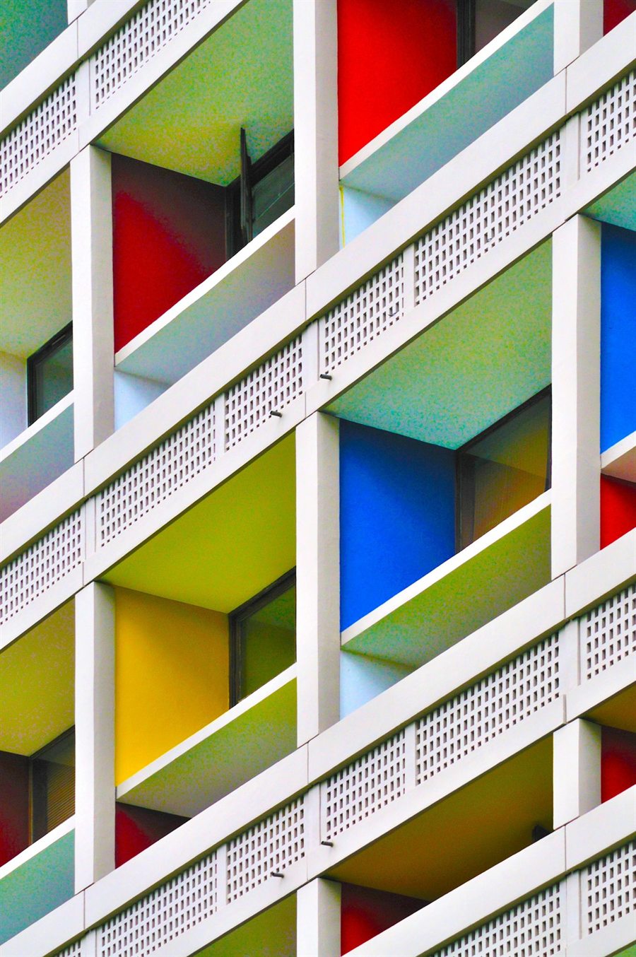 Fassade mit farbigen Loggien in Rot, Blau, Gelb und Grün zwischen weißen Betonrahmen